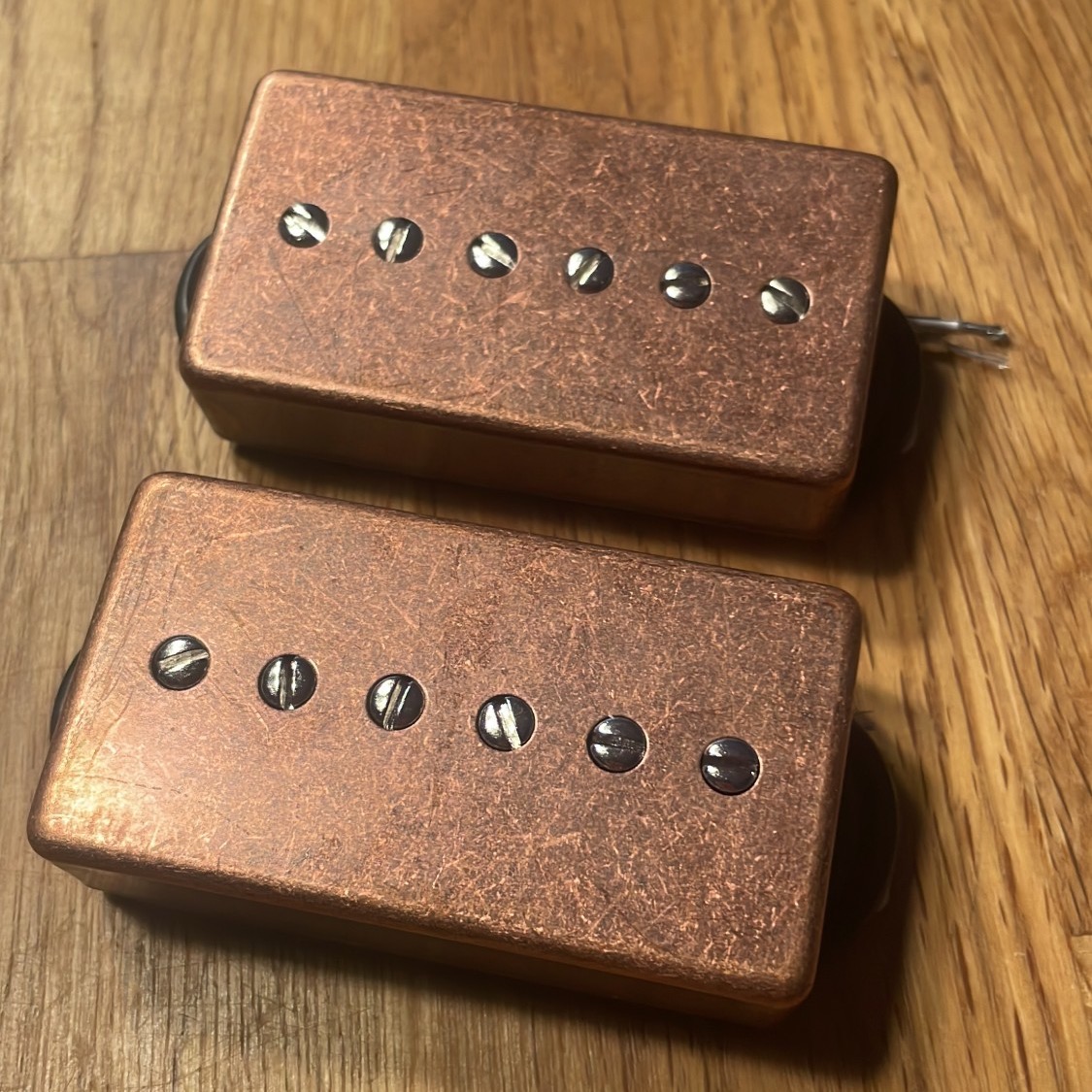P-94 Pickup-Set „Schluggimpfung“ mit Kappen im Finish Antique Copper auf einem Holztisch